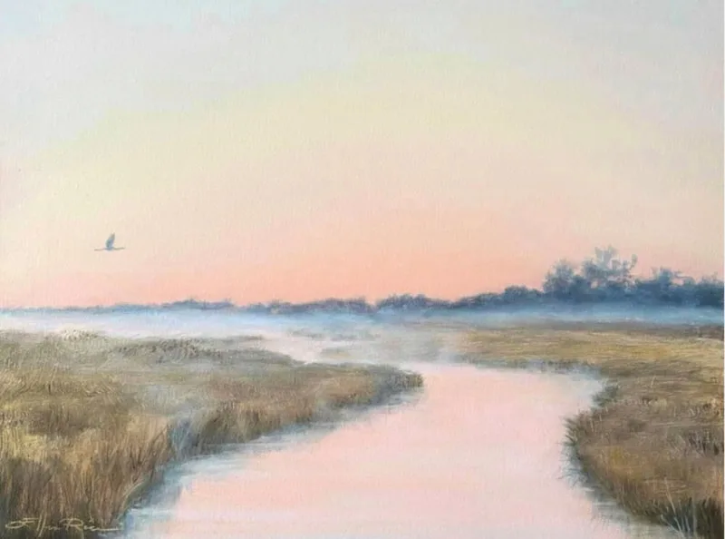 Great blue heron flies above marshlands covered in early morning mist